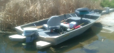 Jon boat with flotation pods attached at stern