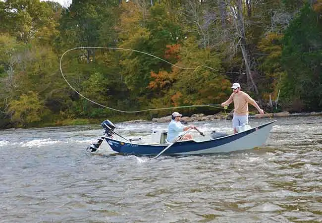 Guy fishing from a drift boat