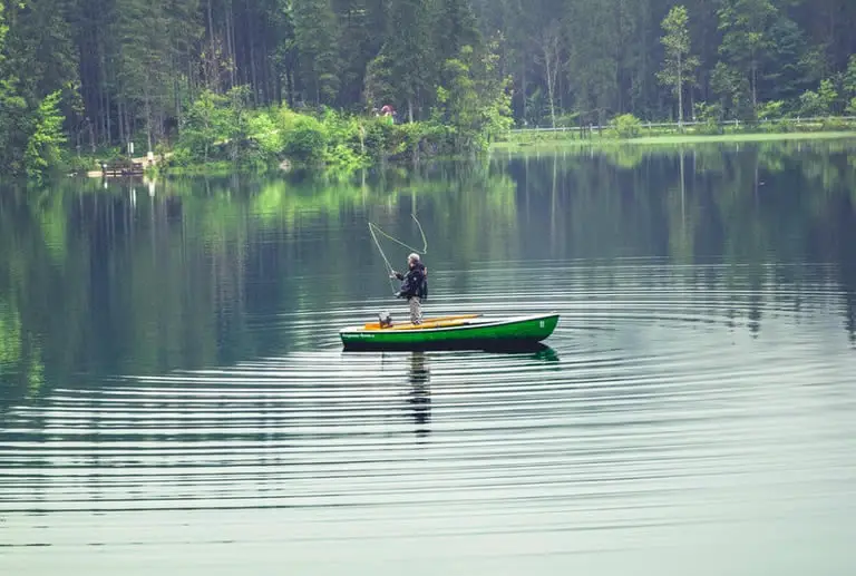 Guy on lake boat fishing on lake