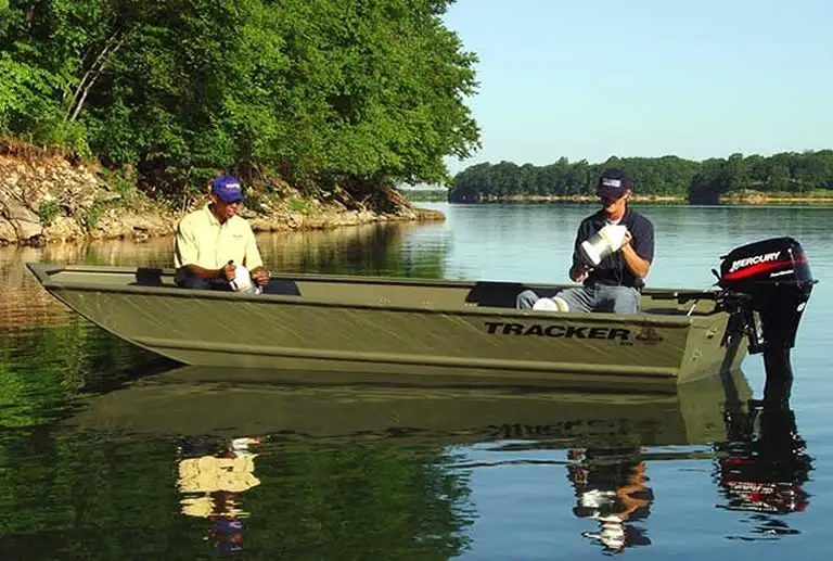 A flat bottom Jon boat sitting in calm shallow water