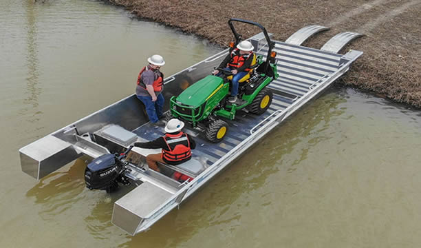 Tractor loaded on flat bottom boat